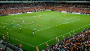 Image of a soccer field with players, coaches, and fans. The image should convey the importance of analyzing team performance and player statistics to make